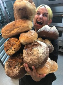 emina holding loads of loaves of bread