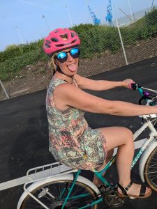 emina on her bike with pink helmet sticking her tongue out